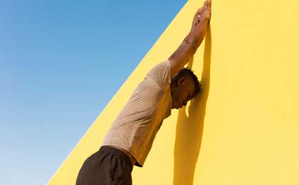 man stretching against wall before exercising